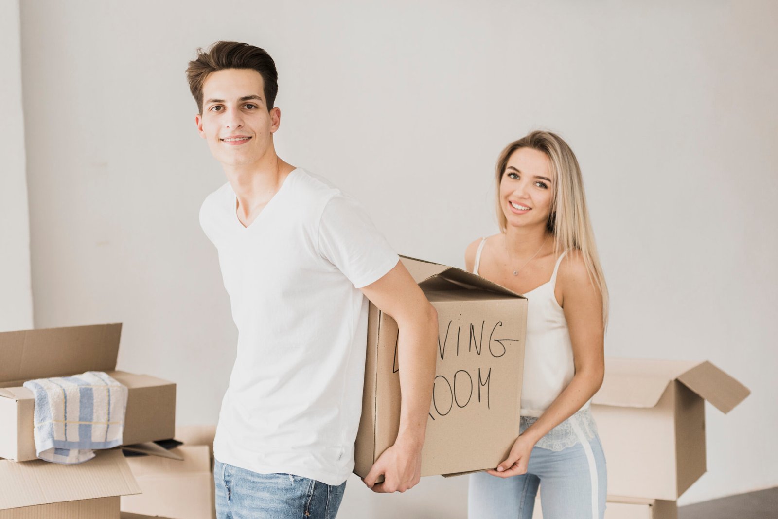young couple carrying box together